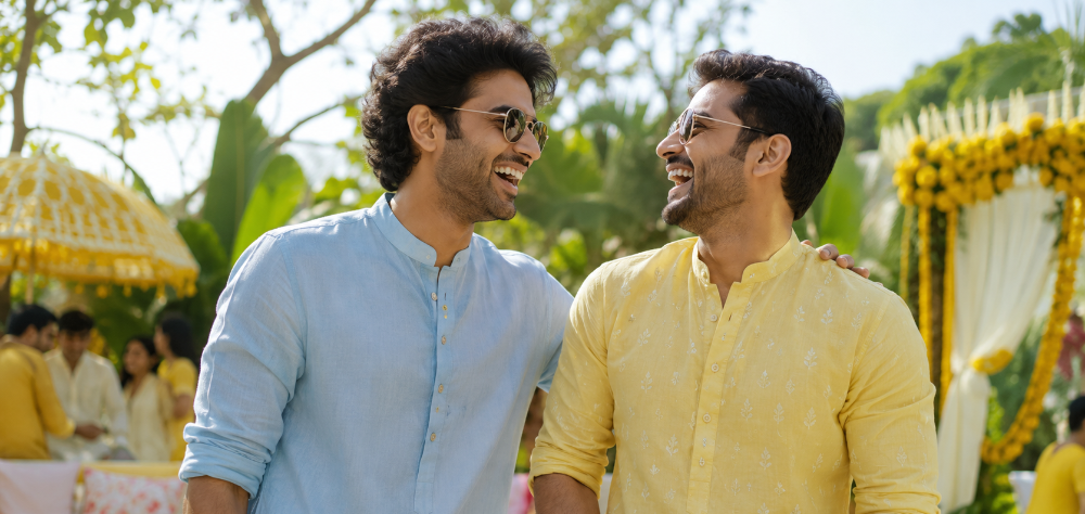 Two Indian men wearing pastel cotton kurtas at a summer outdoor Mehndi ceremony