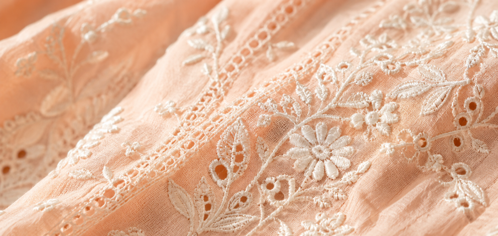 Close up detail of breathable white Chikankari embroidery on summer cotton fabric