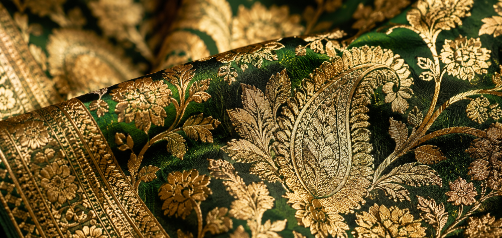 Close up detail of intricate gold zari weaving on a green Banarasi silk lehenga