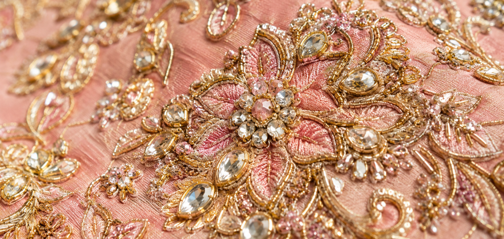 Close up detail of heavy zardozi and crystal embroidery on pristine bridal ethnic wear