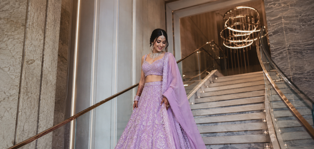 Indian bride walking down stairs in a spectacular lavender pastel lehenga