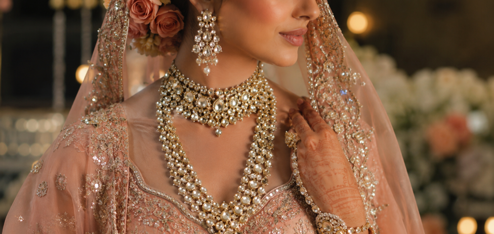 Bridal jewelry featuring uncut diamonds and pearls worn over a peach pastel lehenga